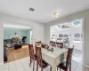 Tiled dining room with ceiling fan and a skylight