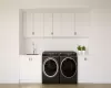 Laundry room featuring washer and dryer, sink, and cabinets