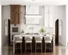 Kitchen with tasteful backsplash, white cabinets, and multiple ovens