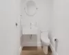 Bathroom featuring wood-type flooring, toilet, and sink