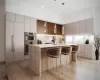 Kitchen with a center island, built in refrigerator, double oven, light stone counters, and a breakfast bar area