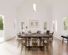 Dining room with light wood-type flooring and a high ceiling