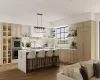 Kitchen featuring light brown cabinets, stainless steel double oven, backsplash, decorative light fixtures, and a kitchen island