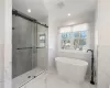 Bathroom featuring tile walls and separate shower and tub