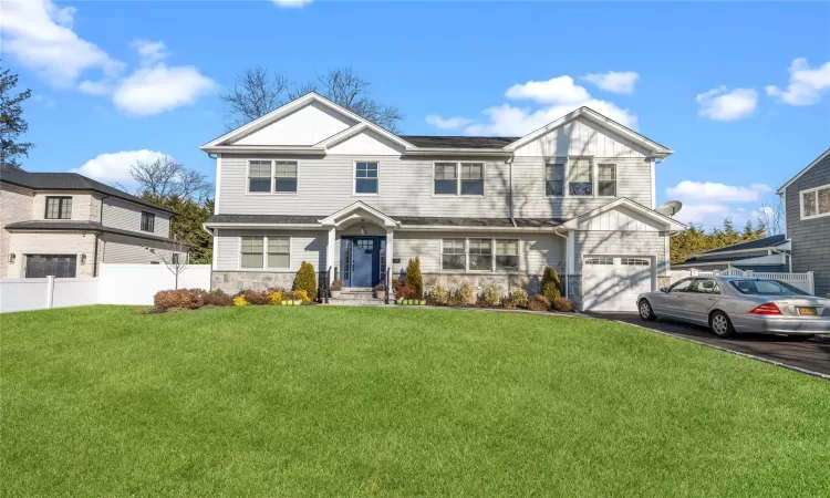 View of front of house featuring a front yard and a garage