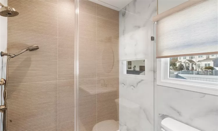 Bathroom featuring toilet and tiled shower