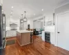 Kitchen with a kitchen island, wine cooler, white cabinetry, appliances with stainless steel finishes, and ornamental molding