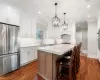 Kitchen featuring a kitchen island, white cabinetry, pendant lighting, and appliances with stainless steel finishes