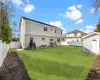 Back of property featuring a yard and a storage shed