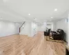 Living room featuring a wall mounted AC, light wood-type flooring, and plenty of natural light