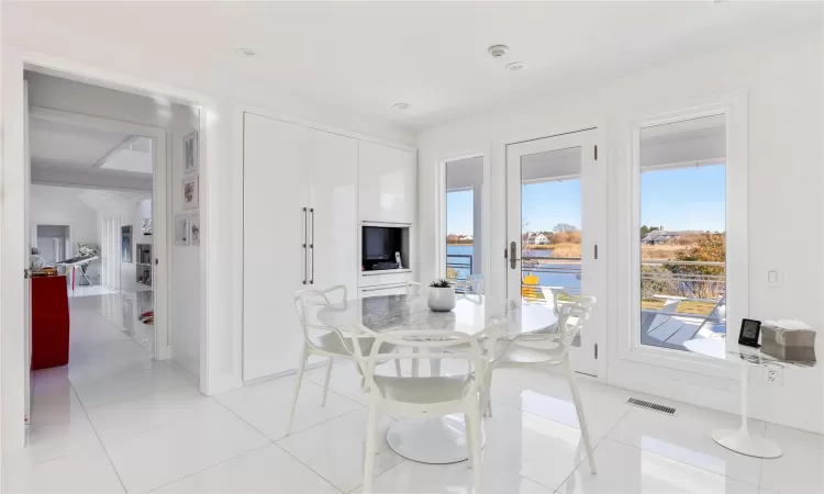 Dining area featuring a water view and light tile patterned flooring