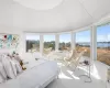 Bedroom featuring light carpet, a water view, and multiple windows