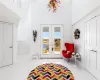 Recreation room featuring french doors, light tile patterned floors, and a high ceiling