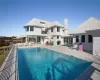 Back of property featuring a fenced in pool and a patio area