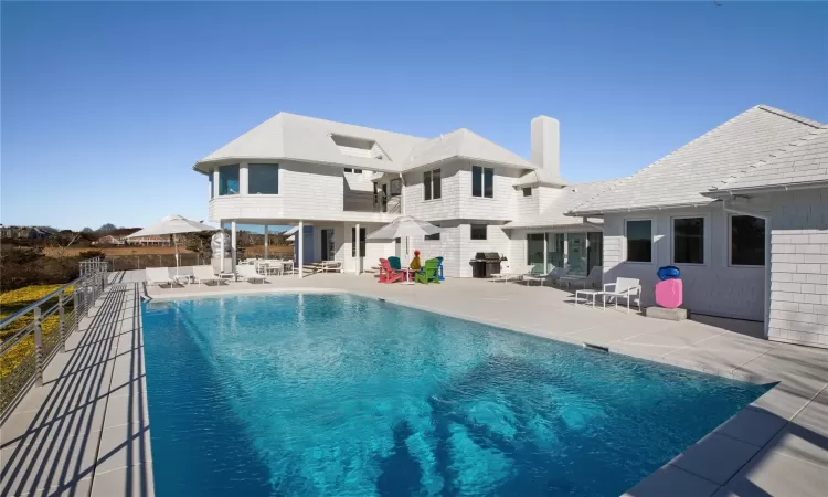 Back of property featuring a fenced in pool and a patio area