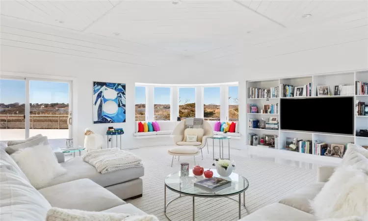 Living room featuring built in features, plenty of natural light, and wooden ceiling