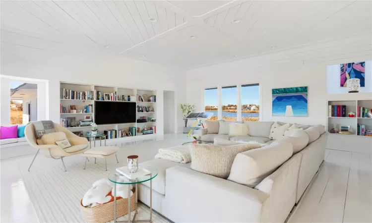 Living room featuring built in shelves, light hardwood / wood-style floors, and wood ceiling