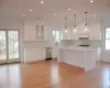 Kitchen with white cabinets, decorative light fixtures, and stainless steel dishwasher