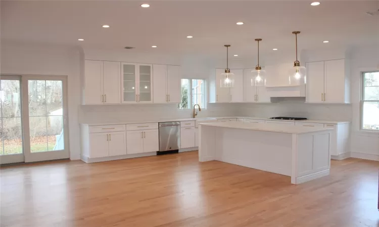 Kitchen with white cabinets, decorative light fixtures, and stainless steel dishwasher