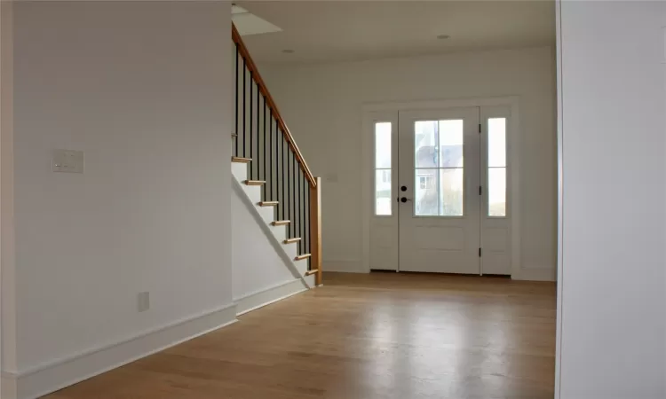 Unfurnished living room featuring a fireplace, crown molding, and light hardwood / wood-style flooring