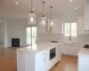 Kitchen with white cabinets, pendant lighting, a kitchen island, and sink