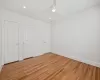 Unfurnished bedroom with light wood-type flooring, ceiling fan, and multiple closets