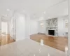 Unfurnished living room featuring an AC wall unit, a fireplace, light tile patterned flooring, and a baseboard radiator