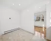 Spare room featuring light tile patterned floors and a baseboard radiator