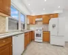 Kitchen featuring white appliances, sink, decorative backsplash, light stone countertops, and light tile patterned flooring