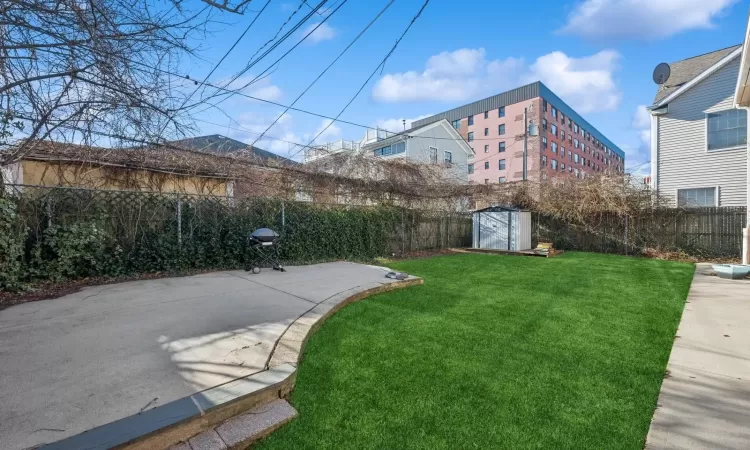 View of yard featuring a storage unit and a patio