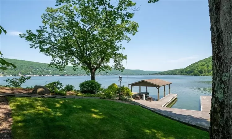 View of dock featuring a lawn, a water and mountain view, and a gazebo