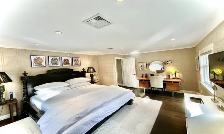 Bedroom featuring crown molding and dark wood-type flooring