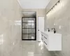 Bathroom featuring tile walls and vanity