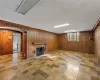 Unfurnished living room with a fireplace and wood walls