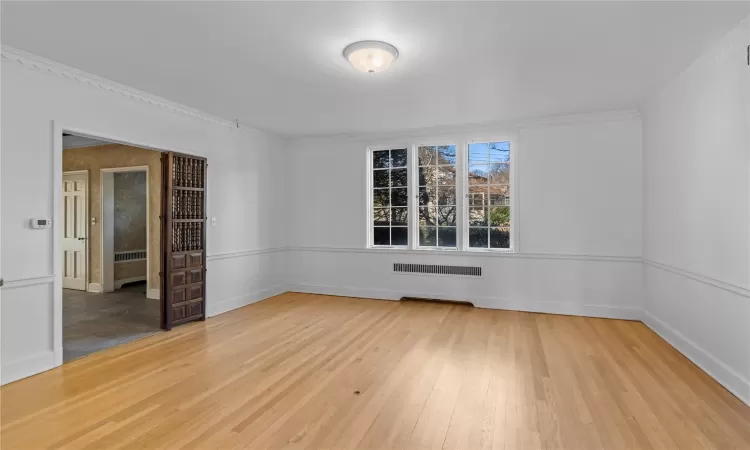 Spare room featuring crown molding and light hardwood / wood-style floors