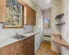 Kitchen with washer and clothes dryer, radiator, sink, and light hardwood / wood-style flooring