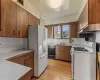 Kitchen with tasteful backsplash, sink, white appliances, and light wood-type flooring