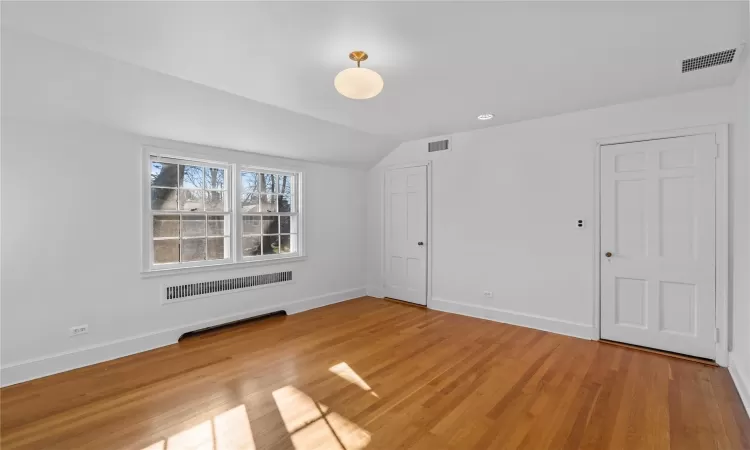 Spare room with lofted ceiling and hardwood / wood-style flooring