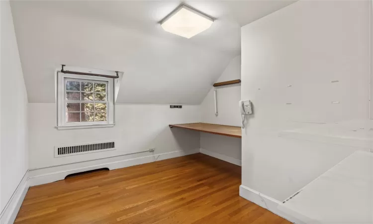 Bonus room with hardwood / wood-style flooring and vaulted ceiling