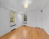 Empty room with lofted ceiling and light wood-type flooring