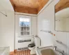 Bathroom with sink, a washtub, tile patterned floors, toilet, and tile walls