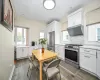 Kitchen featuring exhaust hood, white cabinetry, light hardwood / wood-style flooring, and stainless steel appliances