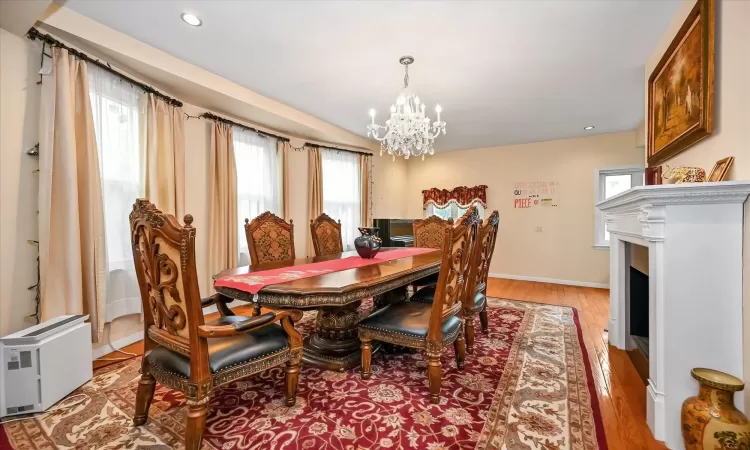 Dining space featuring a wealth of natural light, light hardwood / wood-style floors, and an inviting chandelier