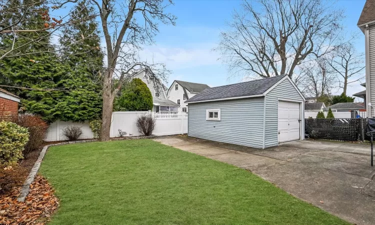 View of yard featuring a garage and an outbuilding