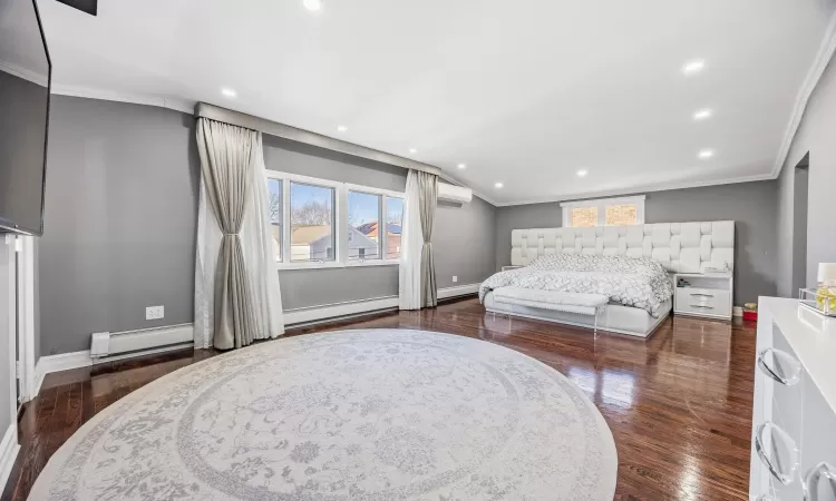 Bedroom with a wall mounted air conditioner, a baseboard radiator, crown molding, and dark wood-type flooring