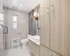 Bathroom featuring vanity, tile patterned flooring, toilet, tile walls, and walk in shower