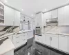 Kitchen with pendant lighting, white cabinetry, and oven