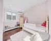 Bedroom featuring a baseboard radiator, dark hardwood / wood-style flooring, an AC wall unit, crown molding, and vaulted ceiling