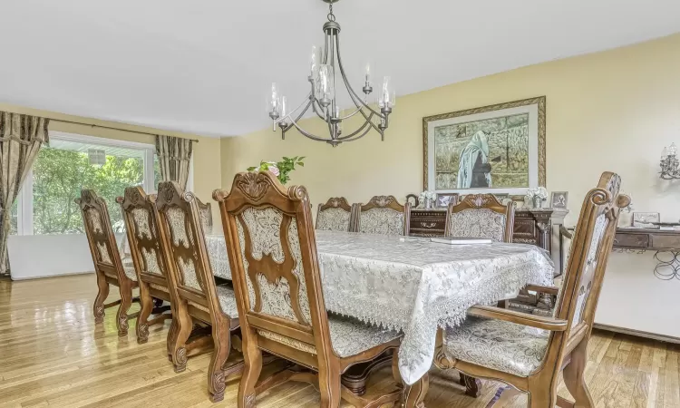 Dining area with a notable chandelier and light wood-type flooring