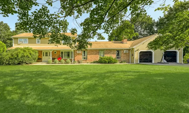 View of front facade featuring a garage and a front lawn